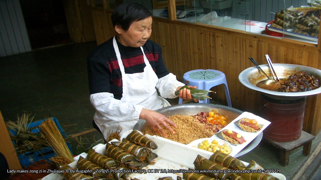Lady makes zong zi in Zhujiajao © By Augapfel - Zong Zi Production Factory, CC BY 2.0, https://commons.wikimedia.org/w/index.php?curid=5049729