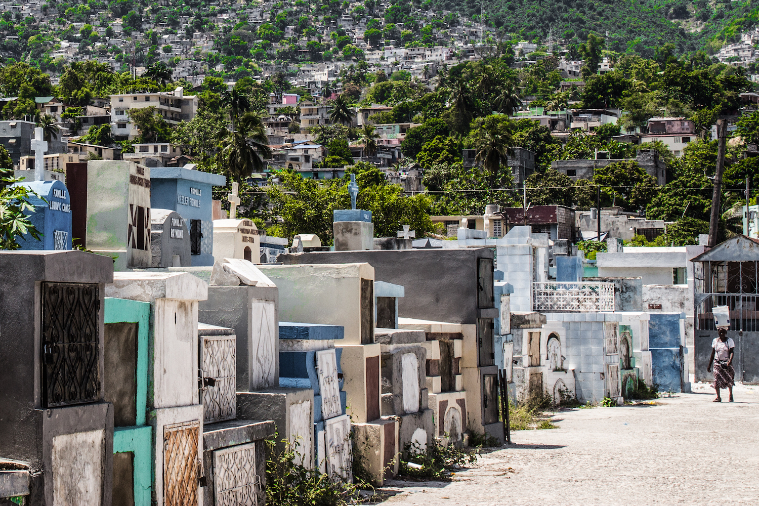 A woman walks between the rows of graves at Le Grand Cimetière. Port-au-Prince, Haiti. © Darmon Richter http://www.thebohemianblog.com/2015/04/haitian-vodou-port-au-prince.html