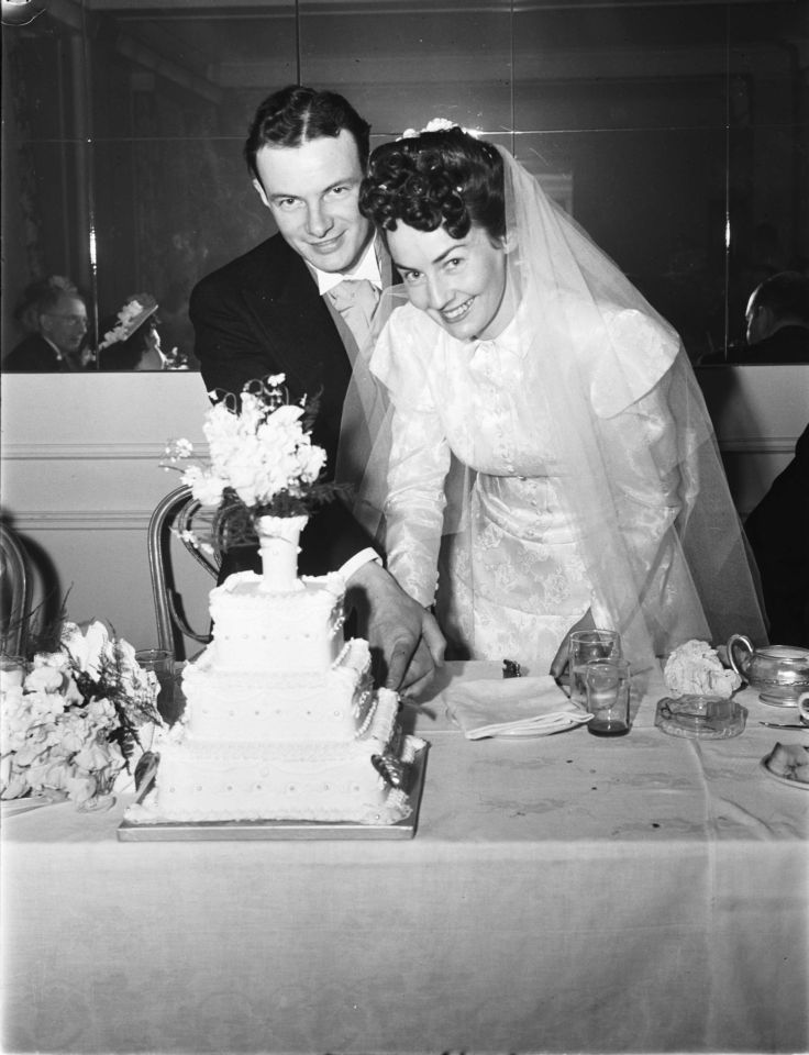 Photo of a couple with their wedding cake