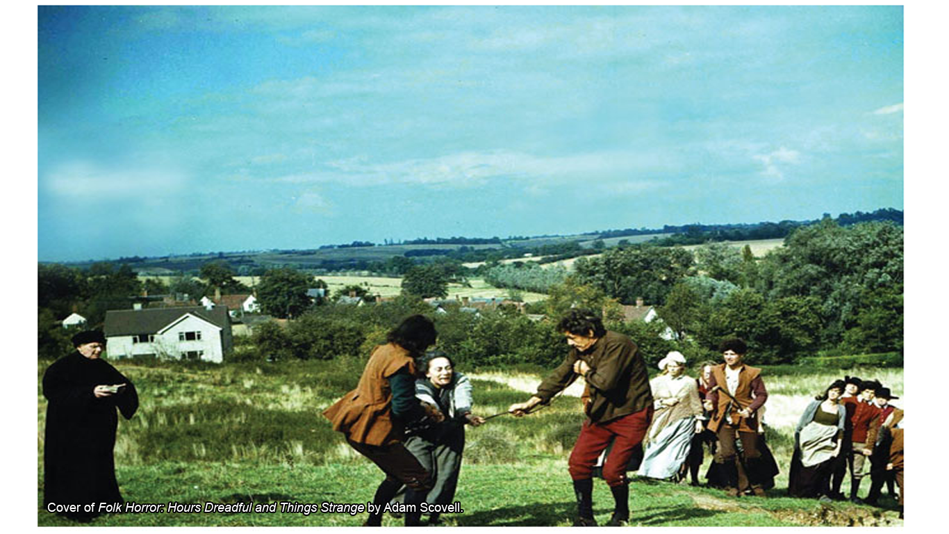 Two men pulling a woman along by the arms in a field, while a crowd looks on.