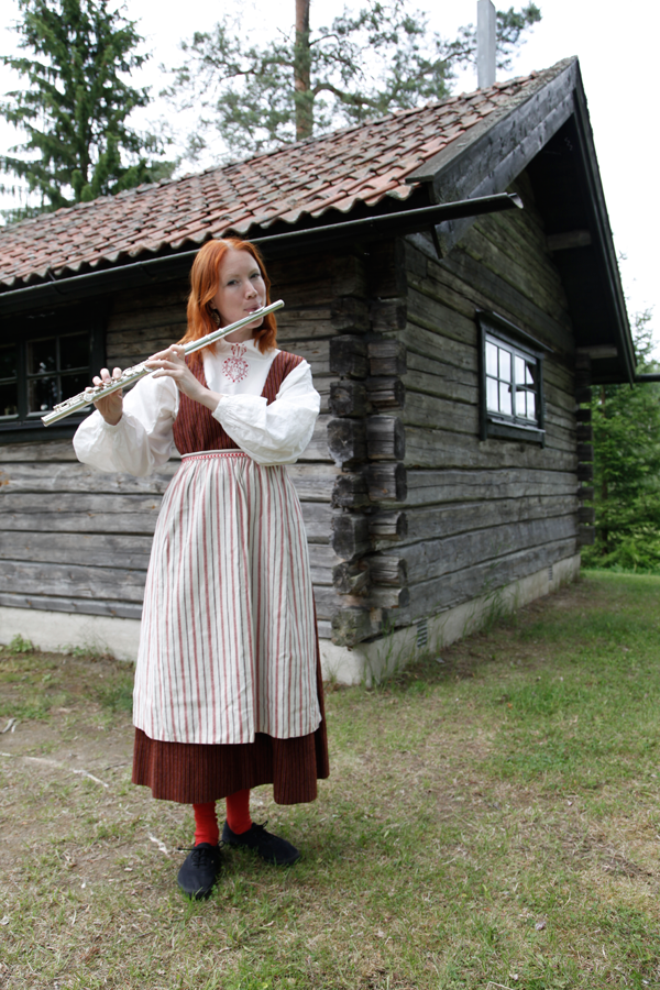 Åsa Larsson, aka Resmiranda, playing the flute in traditional dress.