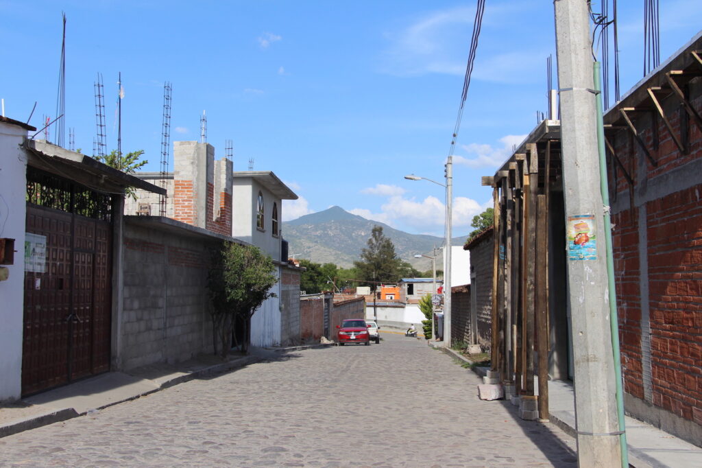 Streets of Mitla; the sacred mountain of Guirún lies in the distance. © Hilary Morgan Leathem