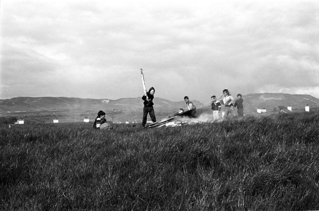 Children sitting around a May Day bonfire, Sligo (May 1993). Photographer: Bairbre Ní Fhloinn. Source https://www.duchas.ie/en/cbeg/46814