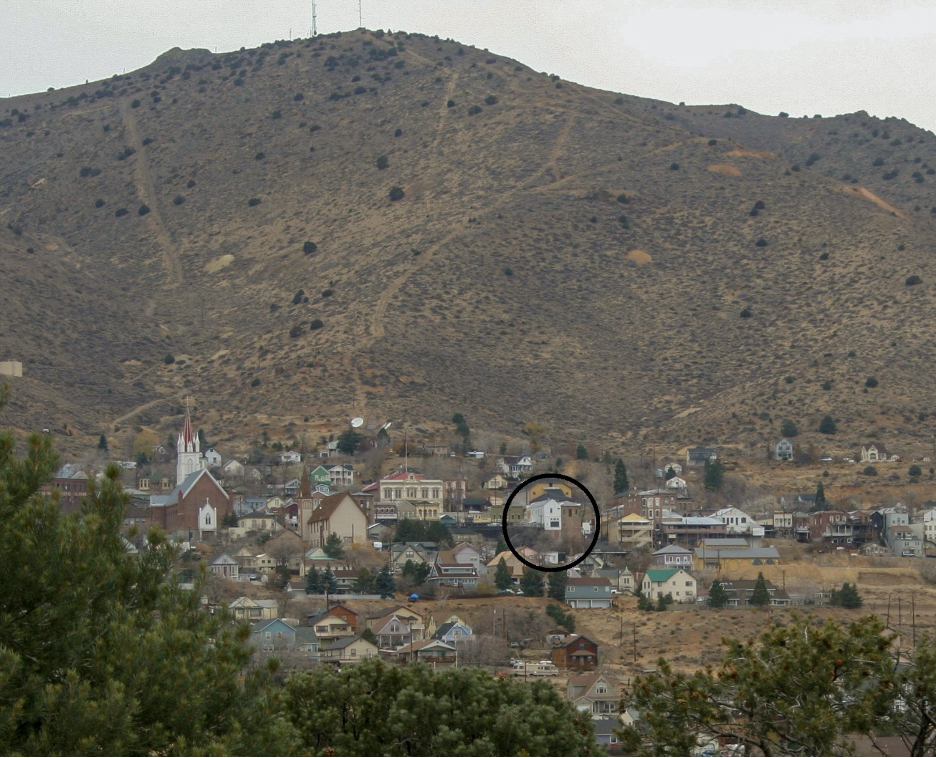 Figure 4. Virginia City from the invented Julia Bulette gravesite. The Bucket of Blood Saloon (the white building within the circle) features a large window that once had a coin-operated telescope, used to view the fabled final resting place of a fallen dove with a heart of gold. Photo by Ronald M James.