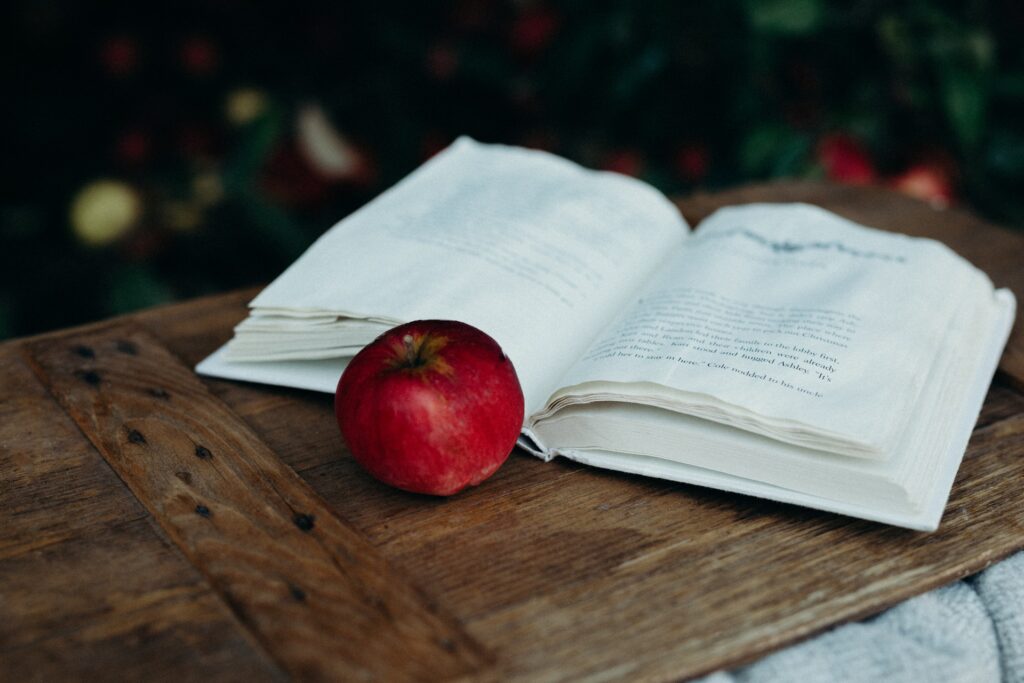Open book with red apple